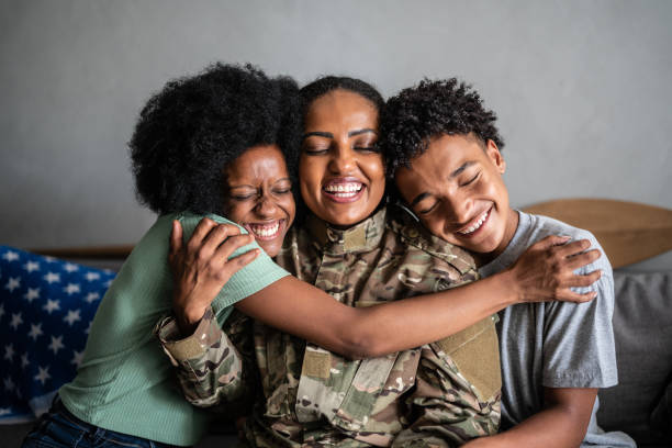 Soldier mother embracing son and daughter at home